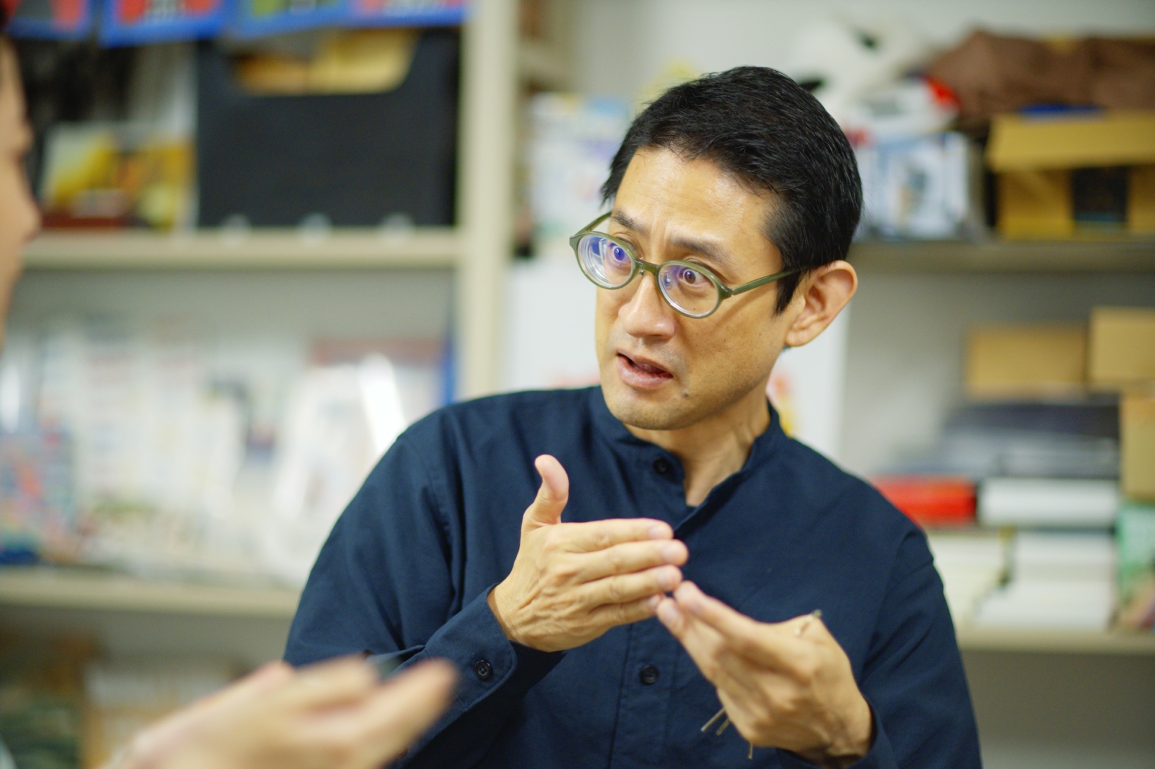 宮城教育大学の研究室で手話の表現をする松﨑丈さんの写真