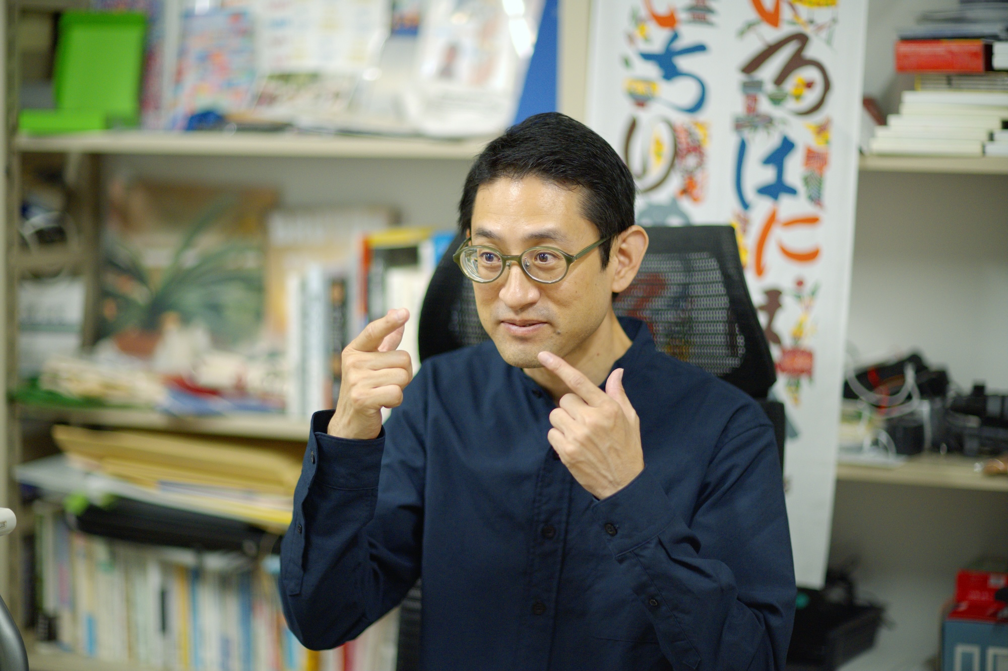 宮城教育大学の研究室で手話の表現をする松﨑丈さんの写真